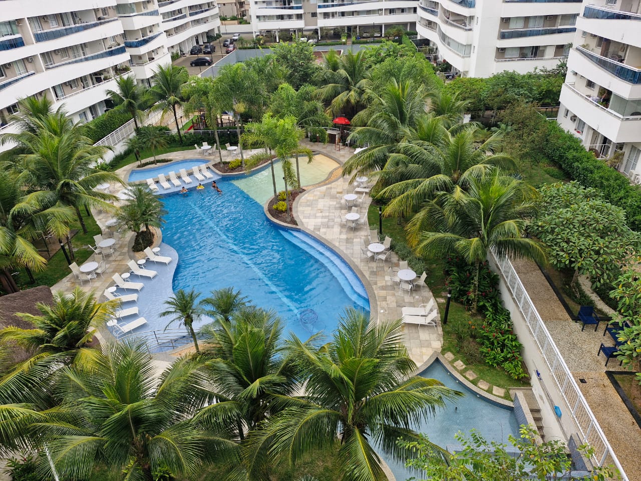 Paisagismo de condomínio residencial com piscina e palmeiras