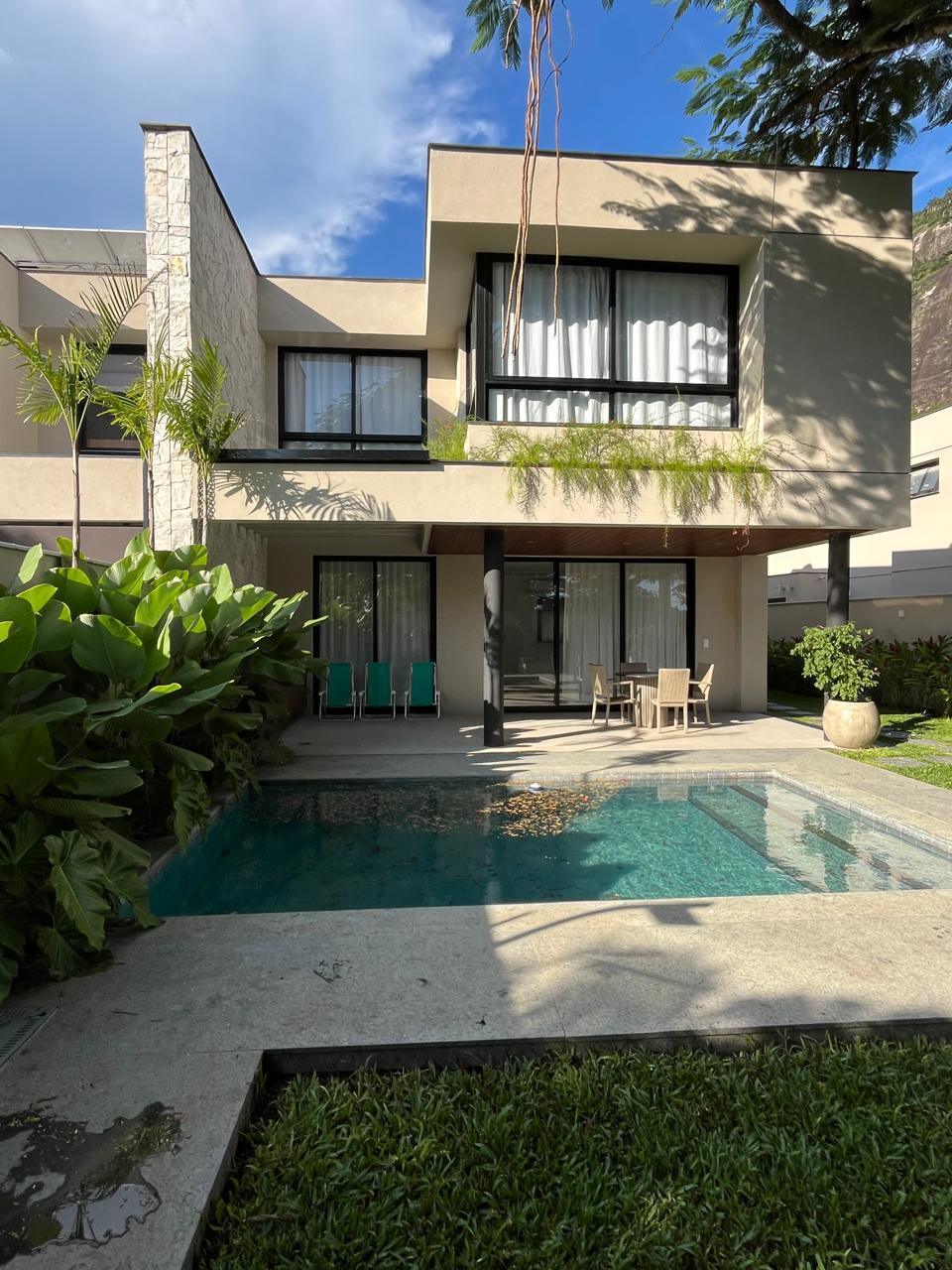 Jardim residencial com piscina e plantas tropicais