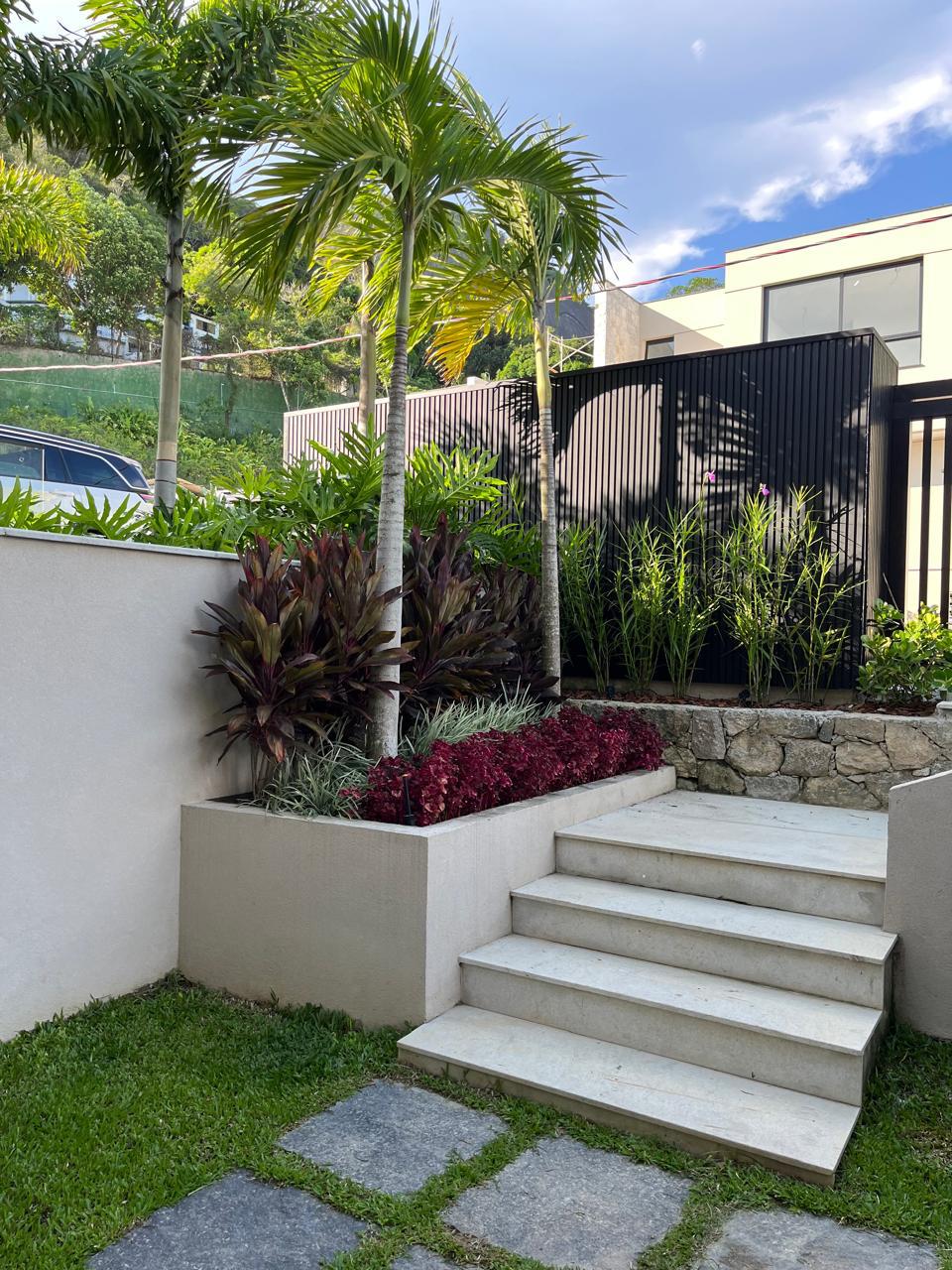 Jardim residencial com palmeiras e escada